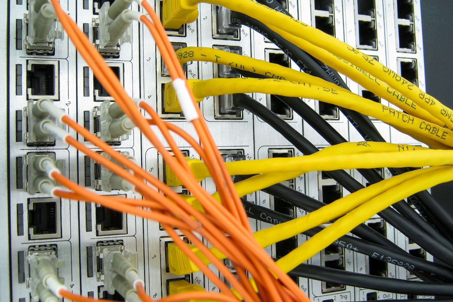 How do optical transmitters handle signal dispersion in fiber optic networks?